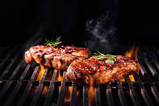Beef steaks on the grill Beef steaks on the grill with flames grilled photos stock pictures, royalty-free photos & images