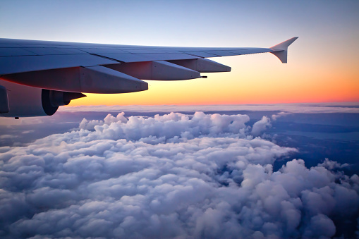 Auckland, New Zealand - May 15, 2016: Looking out the window of an Airbus A380-800 jet airplane at sunset during flight. Photo taken in the evening over the Tasman sea after leaving Auckland International Airport New Zealand