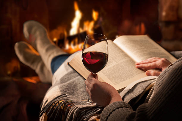 istock Woman reads book near fireplace 531465922
