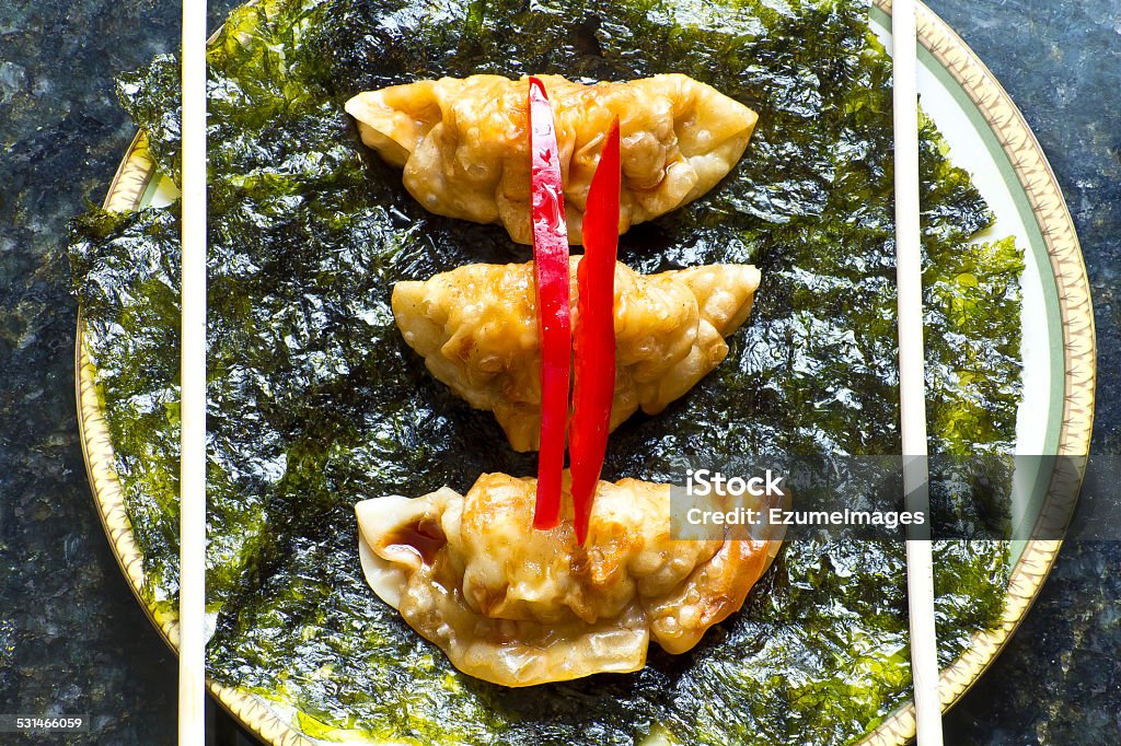 Fried Chinese Dumplings Fried Japanese dumplings on crispy roasted seaweed and red pepper garnish 2015 Stock Photo