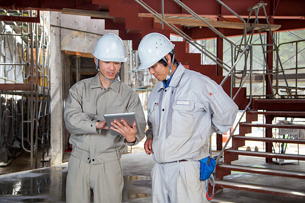 istock Two mid adult construction workers looking at a digital tablet 531467998