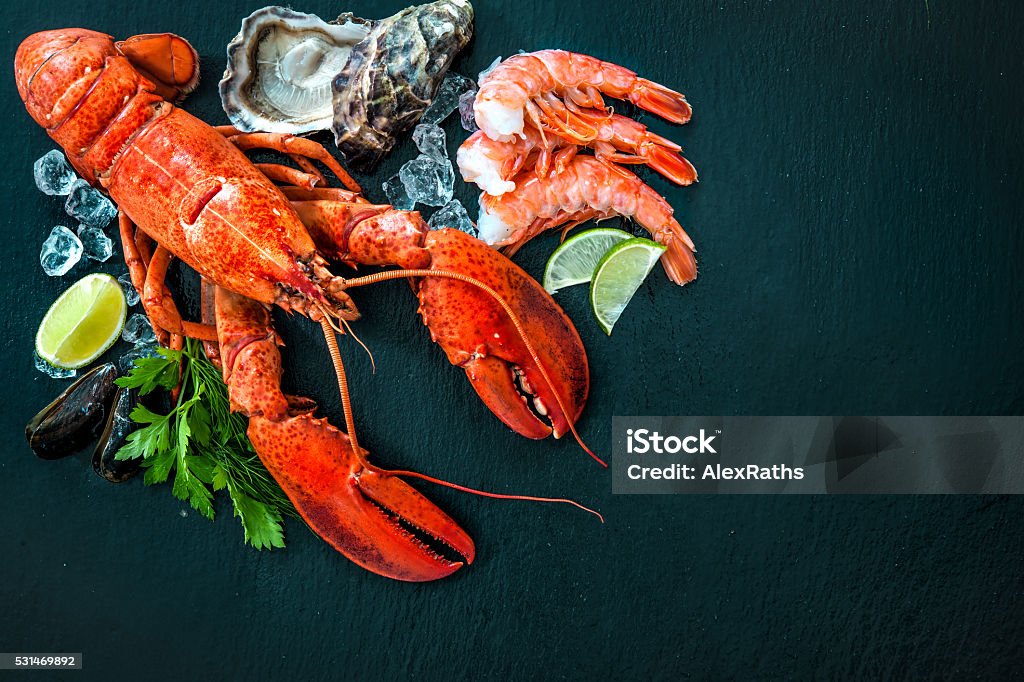 Shellfish plate of crustacean seafood Shellfish plate of crustacean seafood with fresh lobster, mussels, shrimps, oysters as an ocean gourmet dinner background Lobster - Animal Stock Photo