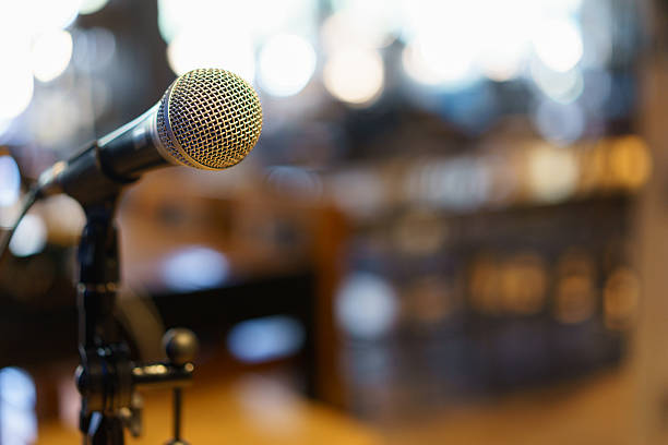 istock Microphone over the Abstract blurred photo of conference hall or 531470584
