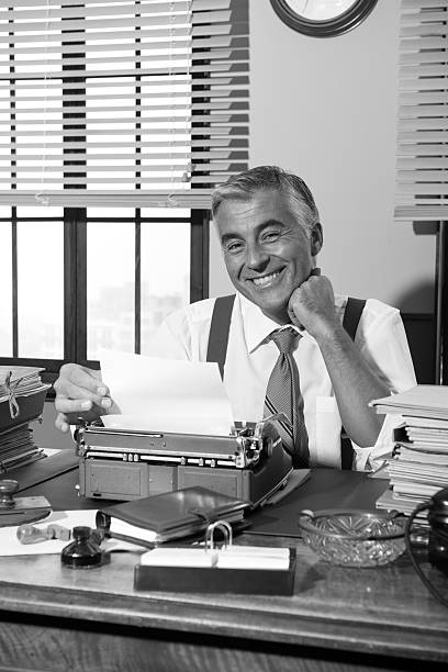 istock Smiling retro reporter working at office desk 531472320