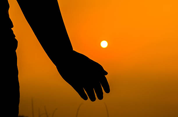 istock hands backlit by a bright evening sun in a closeup 531472782