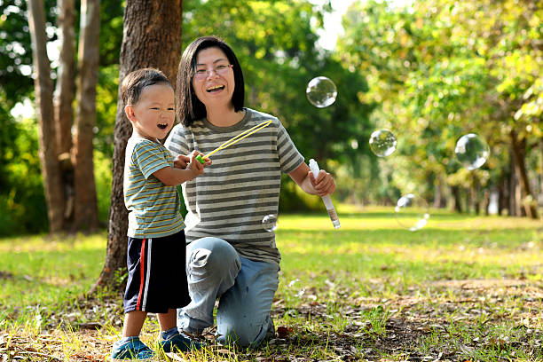 istock Asian child playing bubble wand with mother 531472912
