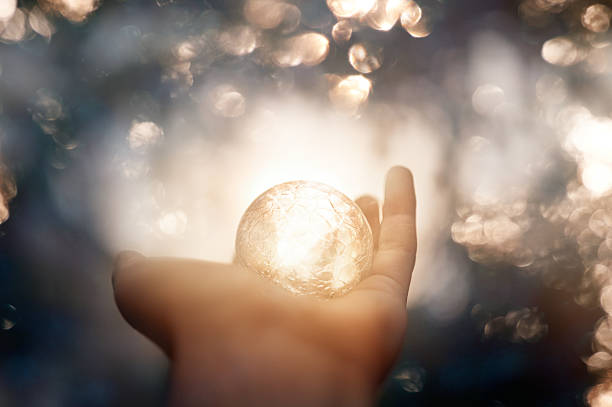 magic moment unrecognizable witch hand holding magic globe, defocused lights in background. magic trick photos stock pictures, royalty-free photos & images