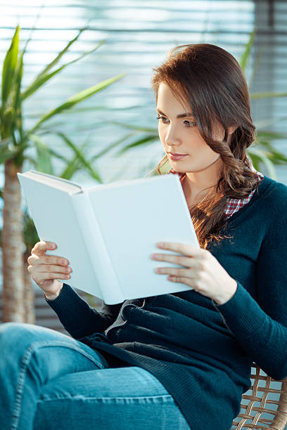 istock Young woman reading a book 531475084