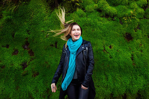 horizontal shot of happy woman in the nature with her flying hair enjoying relaxing day.casual wear.