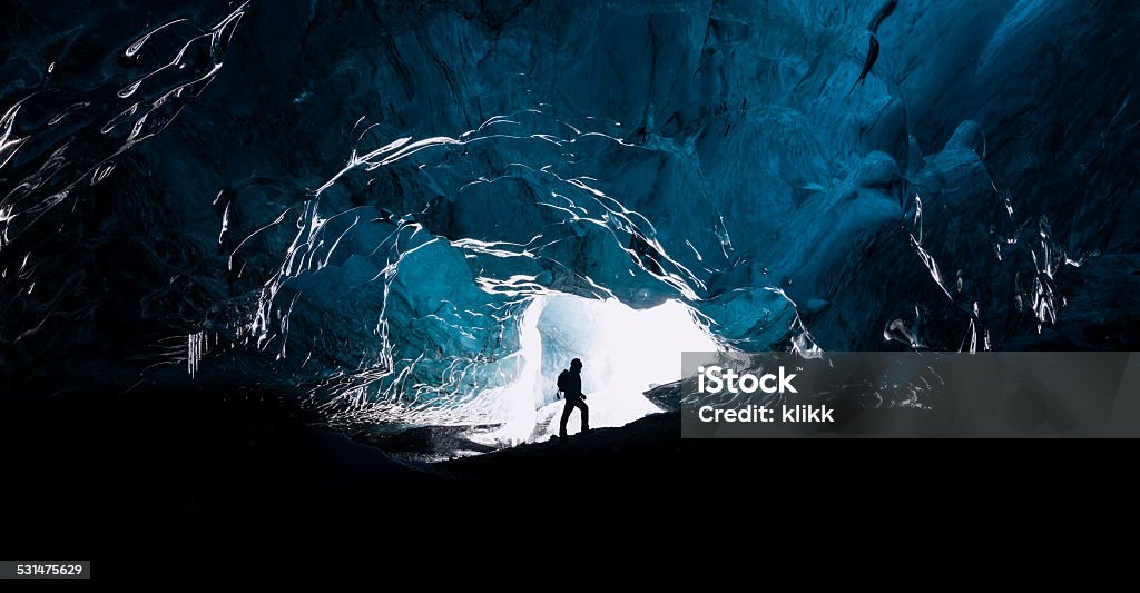 The explorer Man exploring an amazing glacial cave in Iceland Exploration Stock Photo