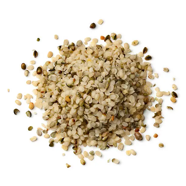 Heap of raw peeled hemp seeds on white background