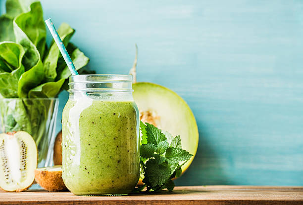 misto frutta frullato fresco verde in barattolo di vetro con paglia - frullato alla frutta foto e immagini stock