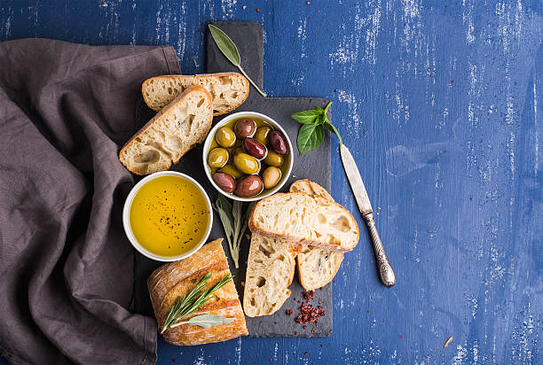istock Mediterranean snacks set. Olives, oil, herbs and sliced ciabatta bread 531478434