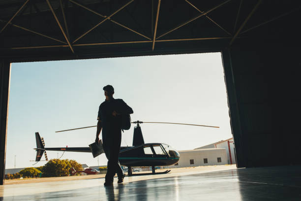 istock Helicopter pilot arriving at airplane hangar 531478436