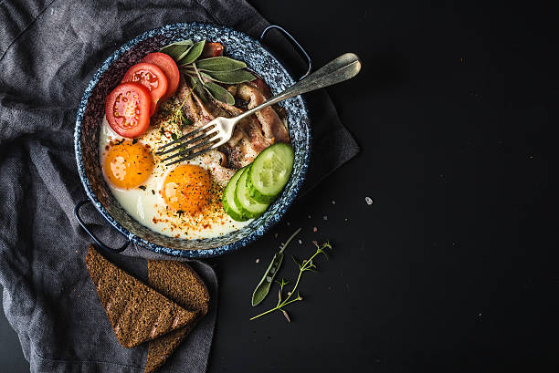 istock Breakfast set. Pan of fried eggs with bacon, fresh tomato 531478600