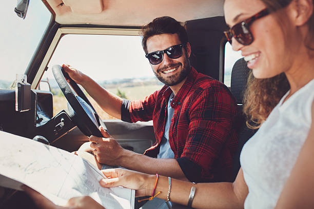 istock Young couple sitting inside their car with map 531478630