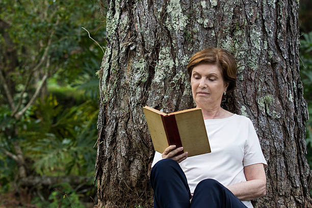 istock Senior Woman Reading a Book Under the Tree 531480126
