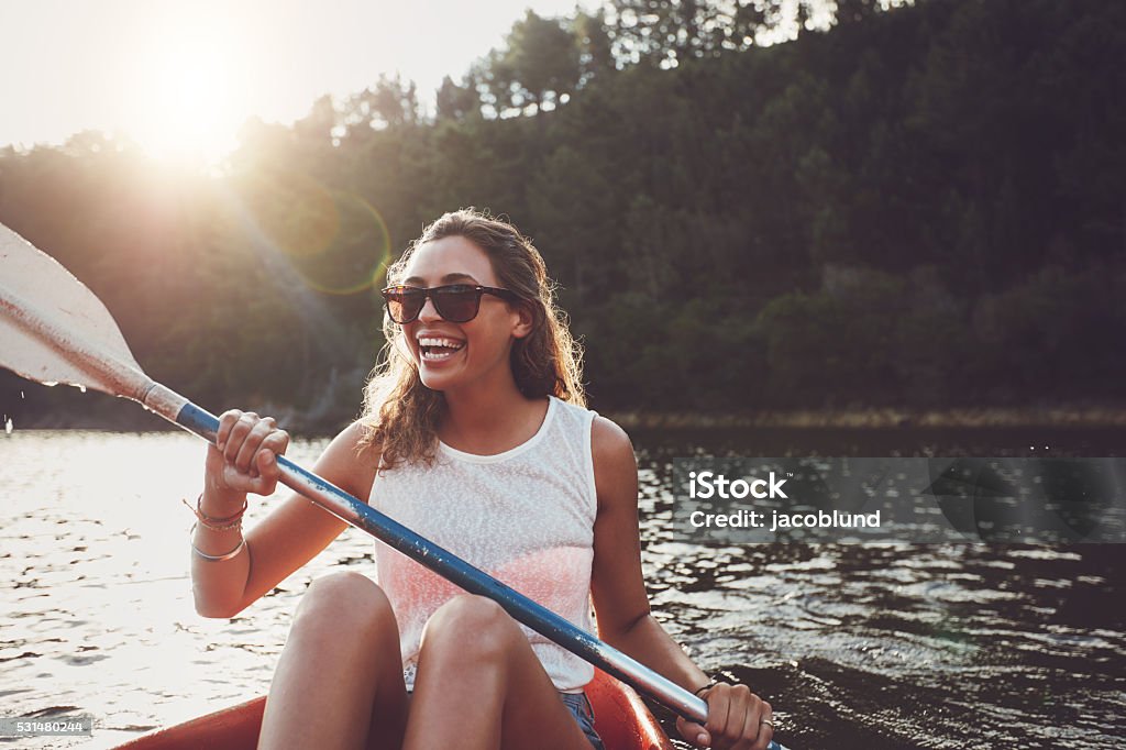Mujer joven sonriente en kayak en un lago - Foto de stock de Mujeres libre de derechos
