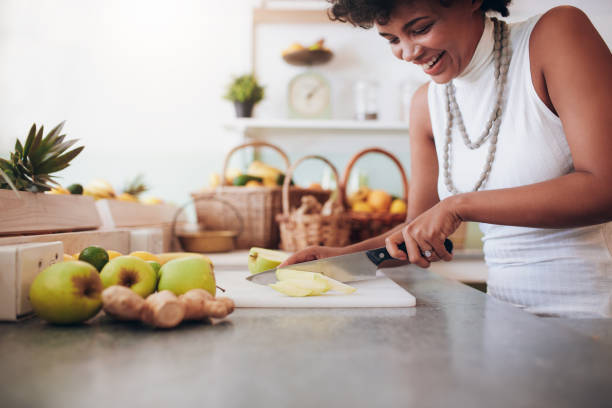 istock Young woman chopping up fresh fruit for smoothie 531481736