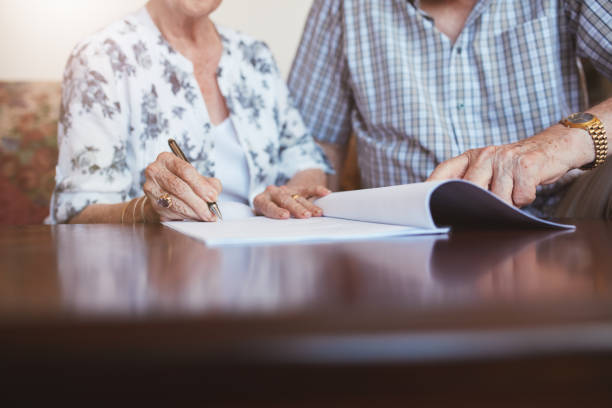 istock Senior woman signing documents with her husband 531483882