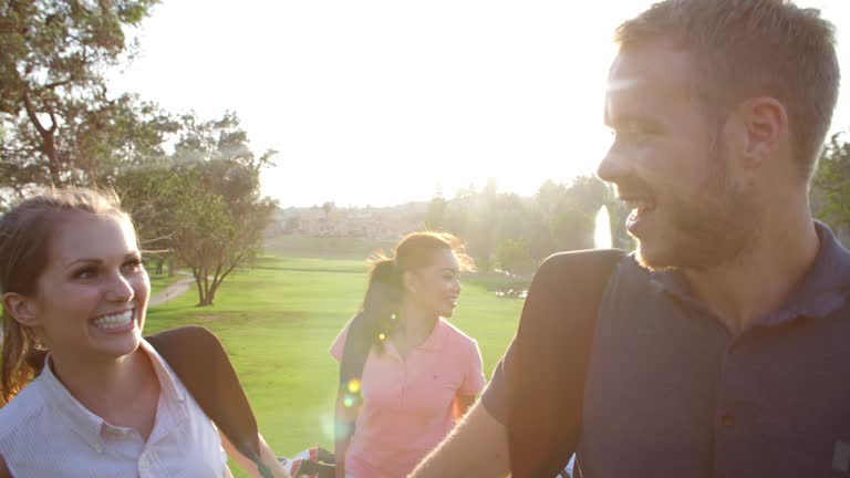 Slow Motion Shot Of Group Of Golfers Walking Along Fairway