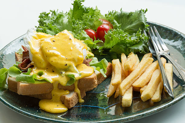 Egg Benedict with french fries stock photo
