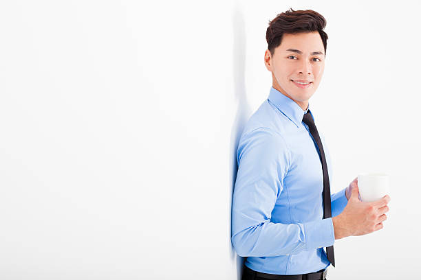 istock relaxed businessman leaning against white wall in office 531489599