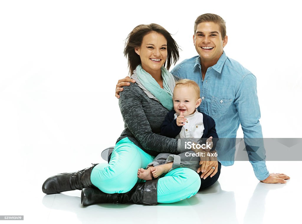 Happy family sitting on floor with their baby Happy family sitting on floor with their babyhttp://www.twodozendesign.info/i/1.png Young Family Stock Photo