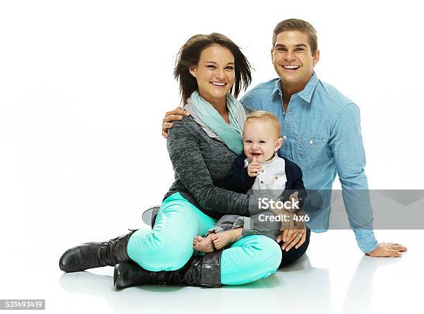 Happy Family Sitting On Floor With Their Baby Stock Photo - Download Image Now - Young Family, 20-24 Years, 20-29 Years