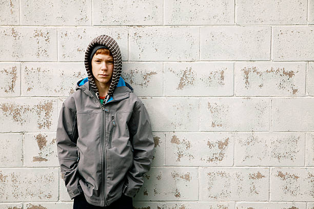 istock Teen Boy Leans Against Brick Wall 531505879