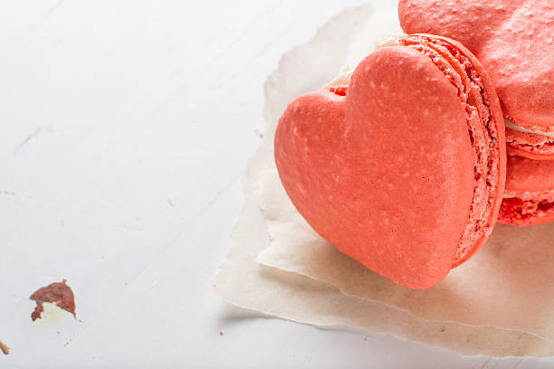 istock Pink heart shaped macaroons on white paper 531507839
