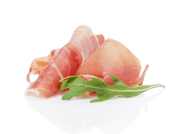 slice of italian prosciutto with arugula leaf slice of italian prosciutto with arugula leaf, isolated on white parma ham stock pictures, royalty-free photos & images