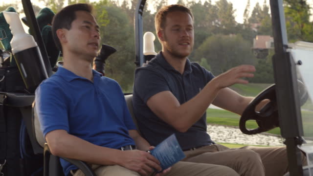 Golfers Driving Buggy Along Golf Course In Slow Motion