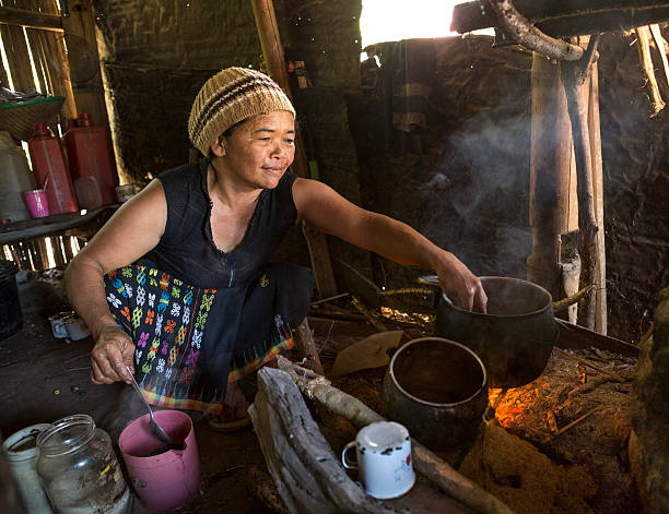 senior donna asiatica, cucinare con fuoco - shack hut old obsolete foto e immagini stock