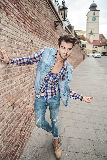 istock handsome man leaning on a brick wall, in the city 531521475