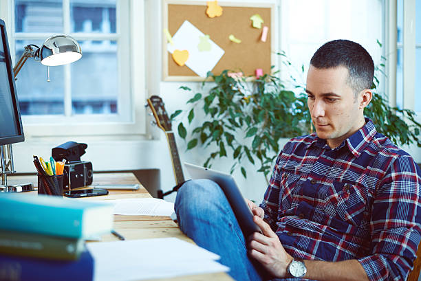 istock Young man in home office reading digital tablet 531521843