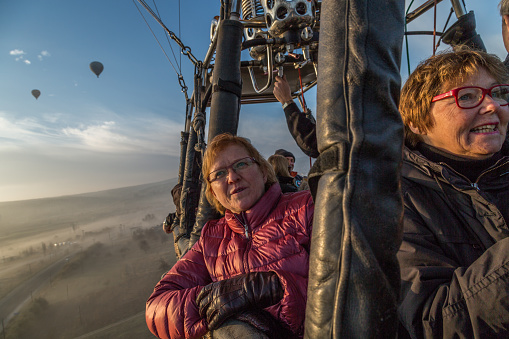 Göreme, Turkey – December 6, 2014: People in a hot air balloon gondola watching the scenery an early winter morning