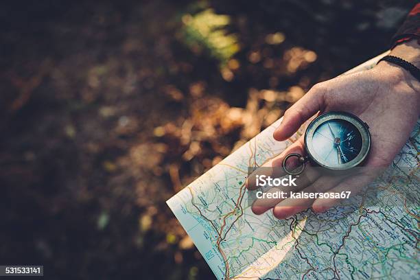 Teenager Girl With Compass Reading A Map In The Forest Stock Photo - Download Image Now