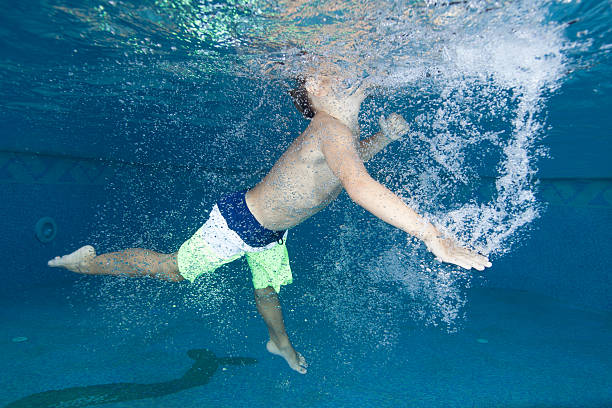 istock Little boy swimming underwater 531534087