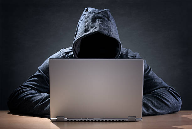 Computer hacker stealing data from a laptop Computer hacker stealing data from a laptop concept for network security, identity theft and computer crime computer hacker spy computer crime laptop stock pictures, royalty-free photos & images