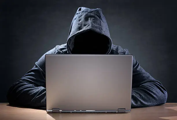 Photo of Computer hacker stealing data from a laptop