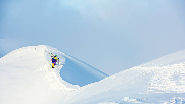 istock Two skiers climbing up a snowy hill 531541360