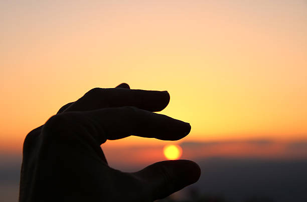 istock hand silhouette aginst the sun. 531543306