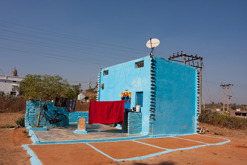 Orchha, India - December 20, 2012: Modern village house of blue color with satellite antenna on the roof on December 20, 2012 in Orchha, India. Town Orchha in Madhya Pradesh state has a population of 10000