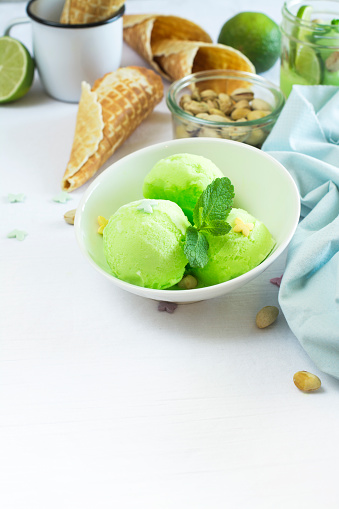Homemade pistachio sorbet with lime, mint leaves, nuts and waffle cones. Selective focus