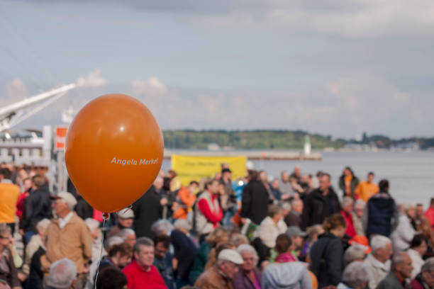 People in the harbour of Stralsund during Merkel's visit Stralsund, Germany - 21 September, 2013: An orange Ballon in front of a crowd of people with the harbour of Stralsund during the visit of the German Chancellor and Leader of the German Christian Democratic Union (CDU) Angela Merkel. chancellor of germany photos stock pictures, royalty-free photos & images