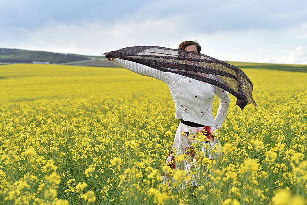 istock Young woman playing with scarf in a canola field 531555708