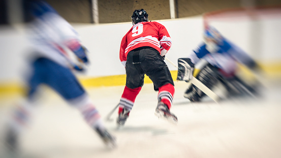 Ice hockey player in action, back view, burred motion