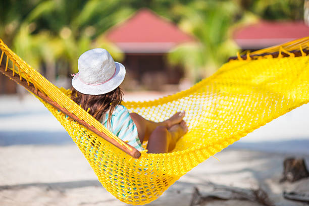 istock Beautiful girl relaxing at hammock on white beach 531565470