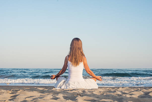 istock Woman meditating at the sea 531567225